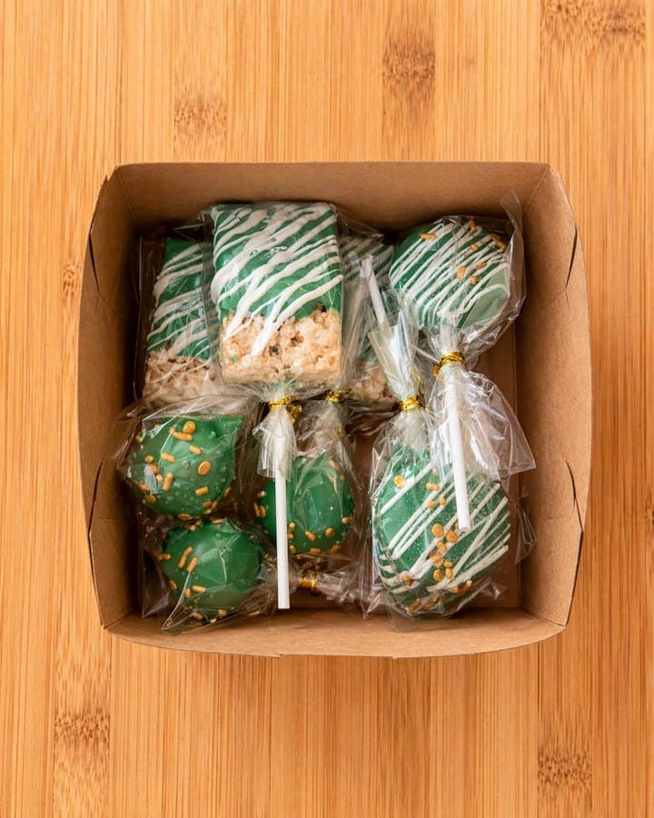 Green themed cake pops and rice crispy treats in kraft box